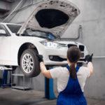 Woman observing a car that is in suspension