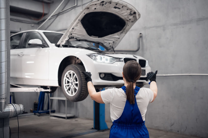 Woman observing a car that is in suspension